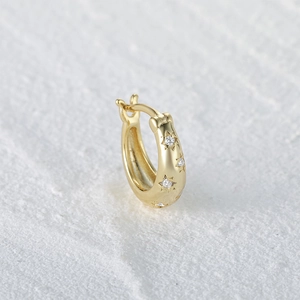 Close-up of gold S925 sterling silver hoop earrings with sparkling star-shaped crystals