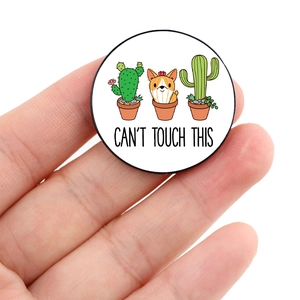 Detail shot of a round Corgi cactus brooch featuring the Can't Touch This slogan