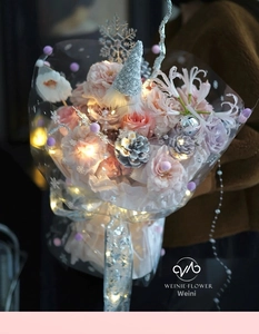 Macro shot of pink roses and white cotton with LED lights in Christmas wrapping paper