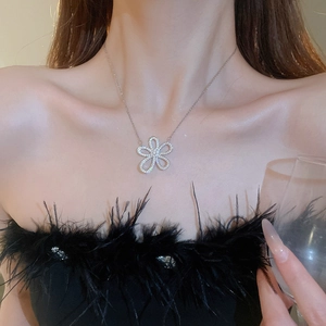 Sparkling silver flower pendant necklace with rhinestones worn on a model's neck