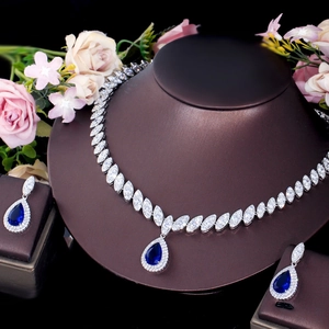Macro detail of tear-drop blue zircon necklace and earrings set on jewelry stand