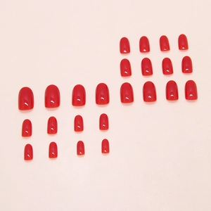Glossy red short round press-on nails set with 24 pieces on a soft pink background