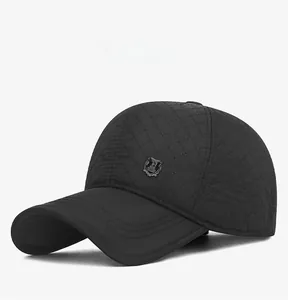 Detailed close-up of a black quilted baseball cap with a metal emblem for winter