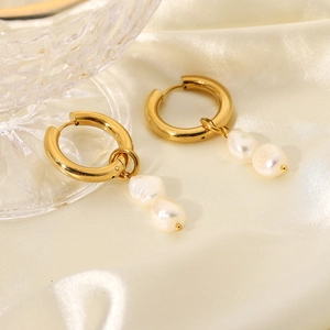 Detail of 18K gold hoop earrings with two vertical baroque pearls on white satin fabric