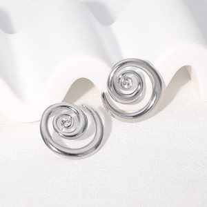 Macro shot of silver stainless steel spiral earrings with a sparkling central zircon inlay