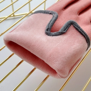 Primer plano del puño de guante de terciopelo rosa térmico con borde ondulado gris