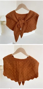 Close-up of caramel knit shawl with geometric hollow pattern and bow tie detail