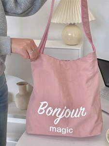 Borsa tote in tela a righe rosa con stampa Bonjour Magic in un set da studio accogliente
