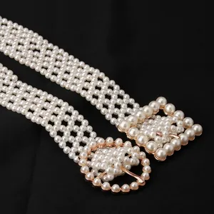 Detailed macro view of an elegant pearl beaded belt featuring a golden buckle and frame