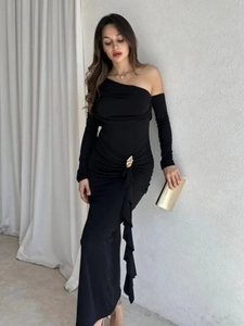 Detailed view of black off-shoulder maxi dress with elegant gold fan-shaped metal buckle