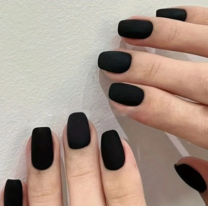 Detailed macro view of short square matte black press-on nails with smooth frosted texture