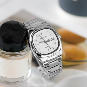 Close-up of square silver steel watch with white dial featuring day and date display