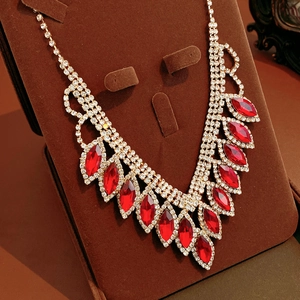 Macro shot of red waterdrop gems and rhinestones on a luxury gold choker necklace