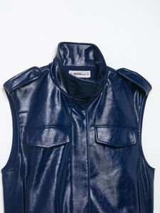 Détail du gilet bleu en similicuir avec épaulettes et poches à rabat ornées de clous