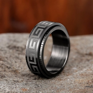 Macro shot of men's dark grey spinner ring featuring a Greek key pattern and anti-slip edges