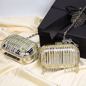 Silver evening clutch bag with sparkling rhinestone tassels and metal chain on silk