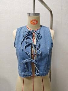 Detail of light blue denim vest for women with stylish front triple bow tie closures