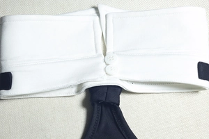 Close-up of the elegant white shirt collar with buttons and black tie detail