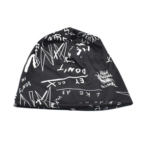 Close-up of black street style knit beanie with white graffiti and text pattern