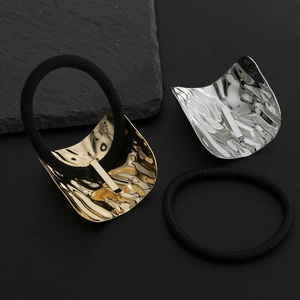 Elegant gold and silver metallic wavy hair ties with textured alloy finish on dark stone