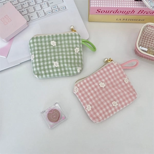 Detail of floral embroidery on plaid cosmetic bags with pearl zipper and wrist strap