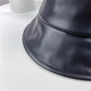 Close-up of black PU leather bucket hat showing lychee texture and fine stitching detail