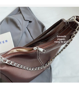 Macro detail of high-quality smooth metal zipper and white contrast stitching on brown bag