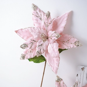 Fleur de Noël poinsettia en velours rose avec paillettes argentées sur fond blanc