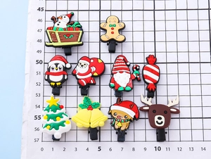 Detailed view of 10 PVC Christmas shoe charms with snowman and Santa on a scale mat