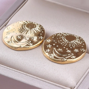 Macro shot of 304 stainless steel celestial earrings with sun and moon relief carvings