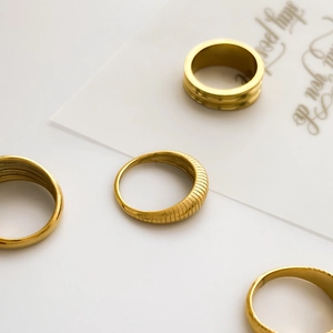 Macro view of gold plated multi-layer rings with textured spring patterns and ribbed details