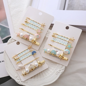 Ocean themed hair clip set with golden starfish, seashell and pearls in a stylish tray