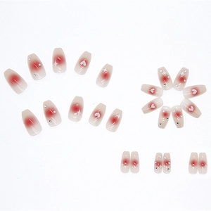 Glossy blush pink ombre press-on nails with heart patterns and rhinestones, 24 piece set