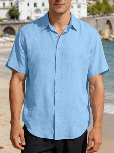 Detailed texture of men's sky blue short sleeve shirt with seaside beach background