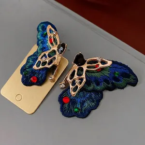Elegant butterfly drop earrings with teal embroidery, crystals and heart charms