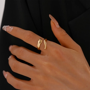 Polished gold snake-shaped open ring showing minimalist design on a model's finger