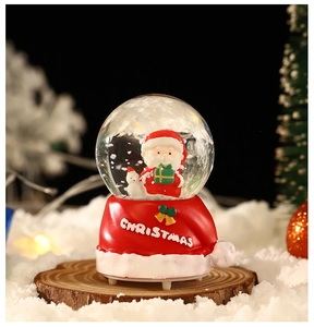 Macro d'une boule à neige Père Noël avec un socle créatif en forme de bonnet rouge de Noël