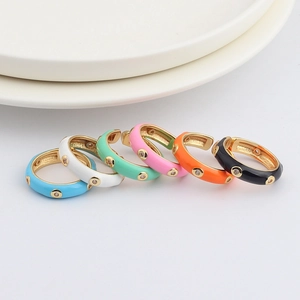 Detail of colorful enamel stackable rings with AAA zircon inlays on white ceramic plate