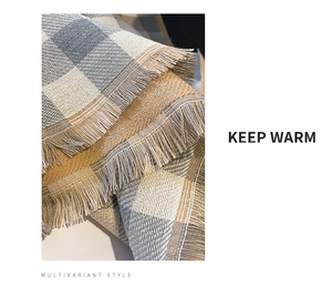 Detail of warm plaid cashmere-like scarf showing texture and soft fringe tassels