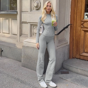 Detailed close-up of grey knitted long sleeve top and flared pants set on model