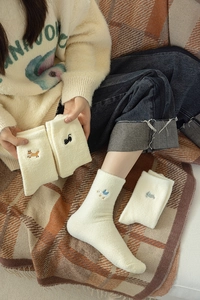 Detail of warm thermal socks with cute animal embroidery featuring fox, cat, duck and rabbit
