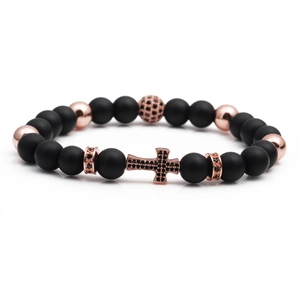 Close-up of beaded bracelet with rose gold cross pendant and micro-set zircon stones