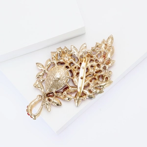Close-up of the vintage golden leaf brooch back with metal texture and safety pin clasp
