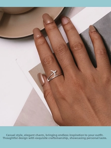 Close-up of S925 silver airplane ring with zircon wings worn in a lifestyle setting