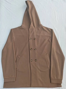 Close-up of brown hooded trench coat with double-breasted buttons and side pockets