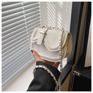 Close-up of white leather saddle bag with chain strap held against a neutral background