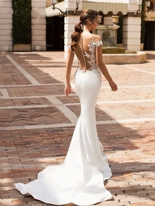 Detail of mermaid wedding dress featuring illusion back with lace and pearl buttons