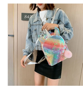 Girl wearing rainbow sequin unicorn backpack with pink pom-pom and silver glitter ears