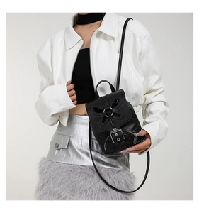 Mini sac à dos élégant en cuir noir pour femme, avec design papillon tendance et anneau métallique.