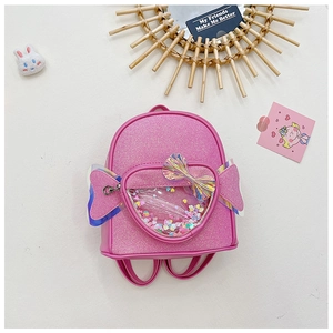 Close-up of pink sequin kids backpack with heart-shaped window and iridescent wings